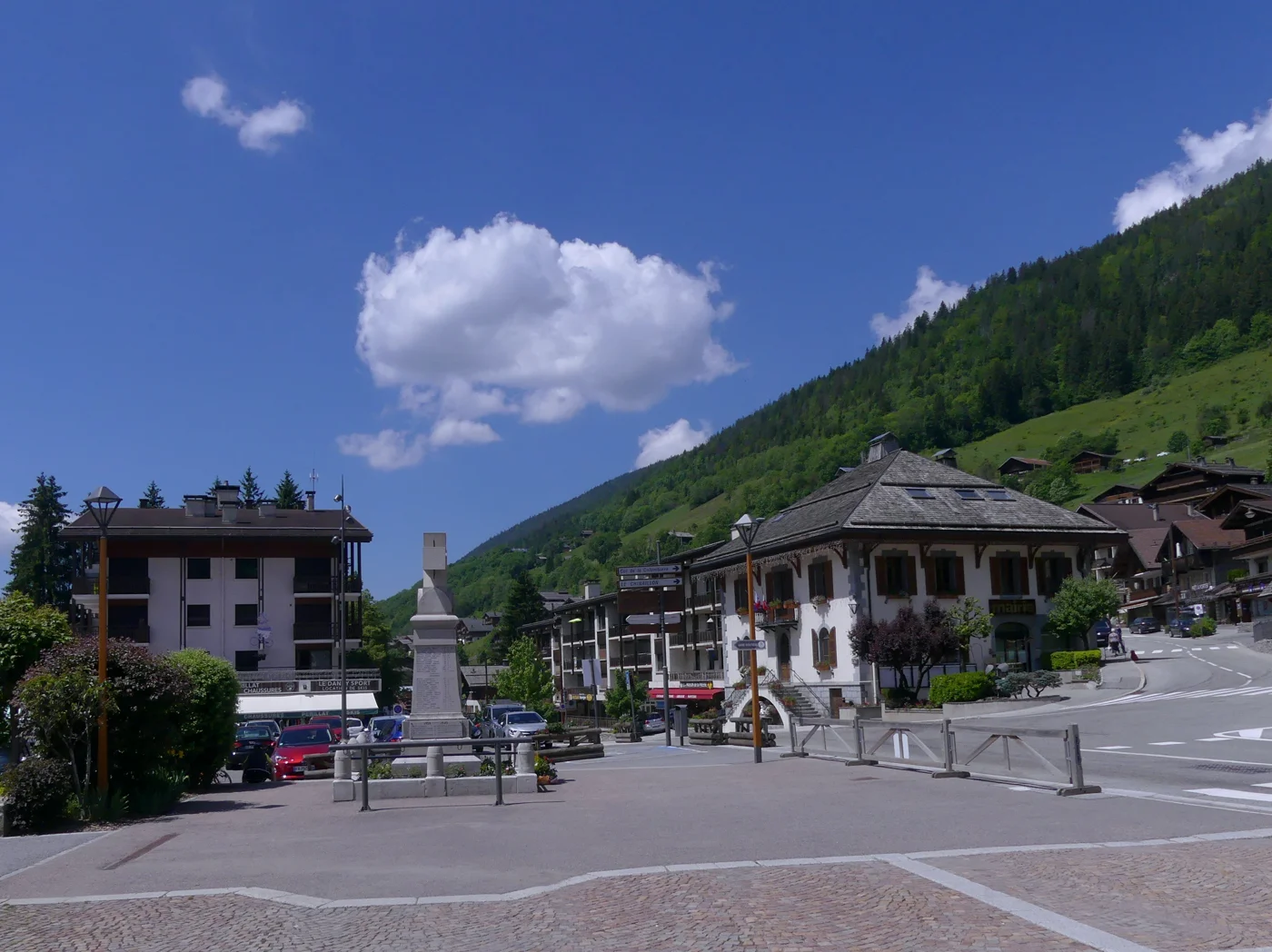 Centre du Grand-Bornand, avec la mairie, les commerces et le versant boisé en arrière-plan.