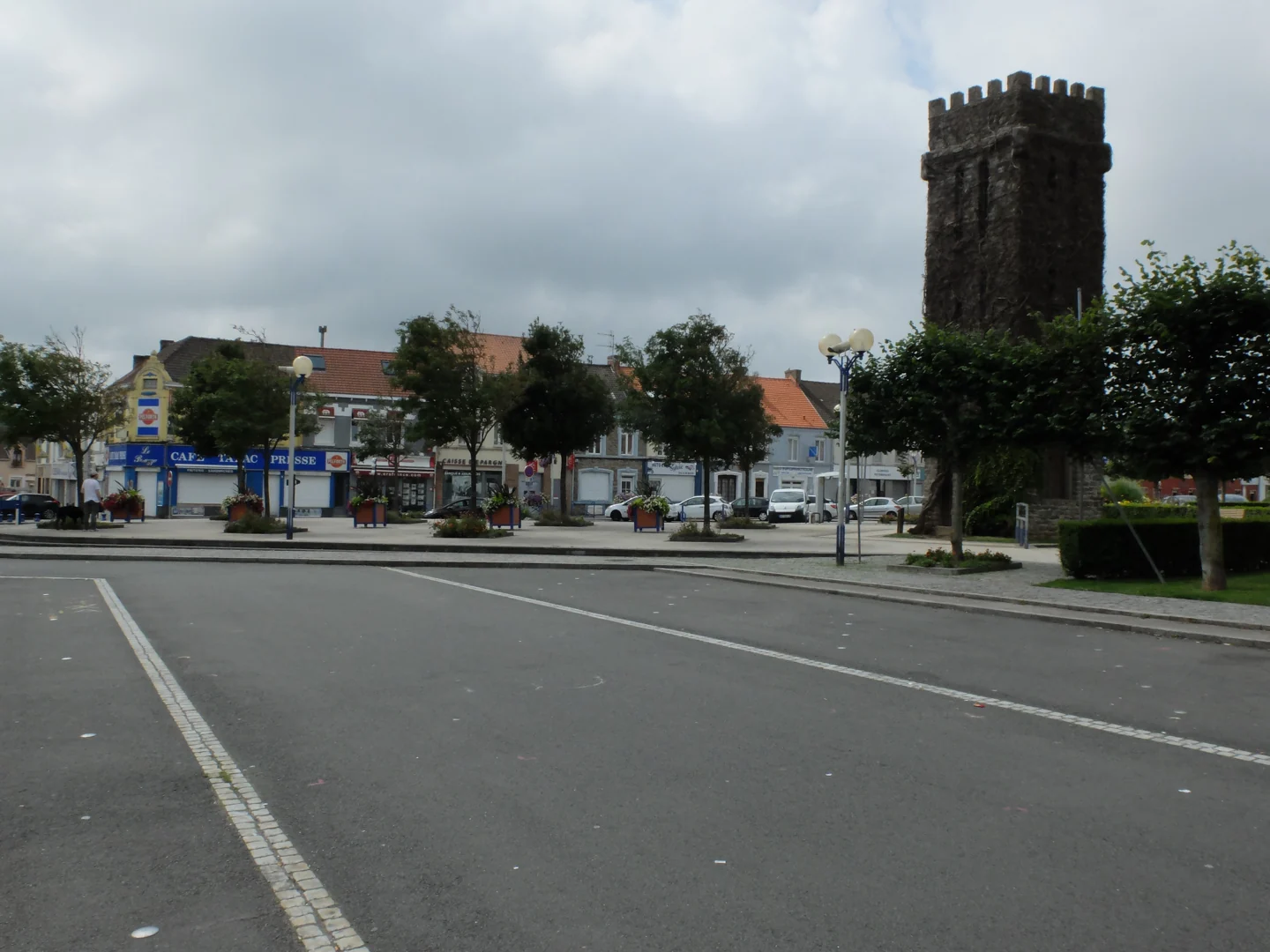 Place du centre d’Outreau, avec la tour de l’ancien château Lonquéty à droite et des commerces en arrière-plan.
