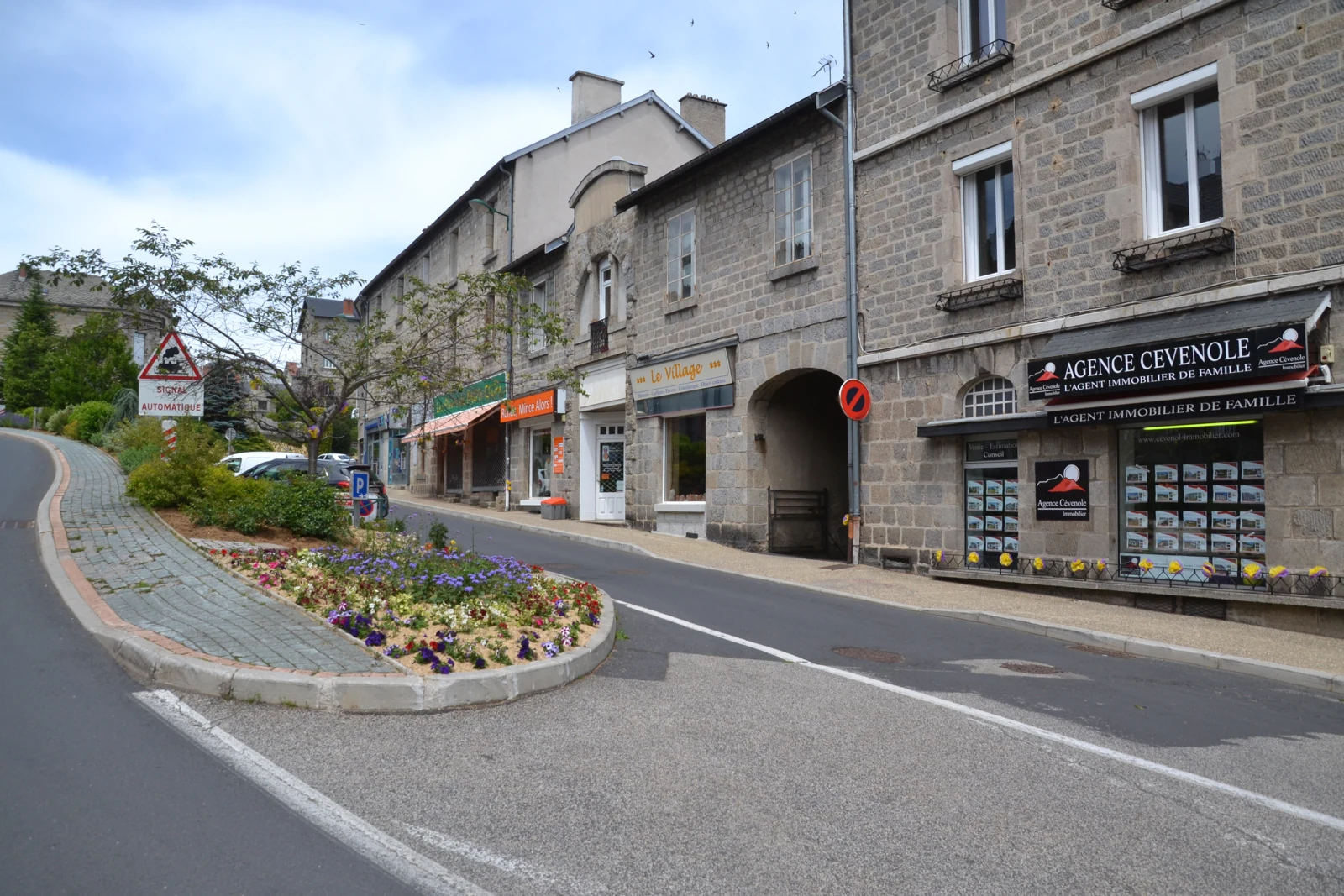 Façades en pierre et rue fleurie au Chambon-sur-Lignon, photographiées en 2019 ; vue de contexte postérieure aux faits.