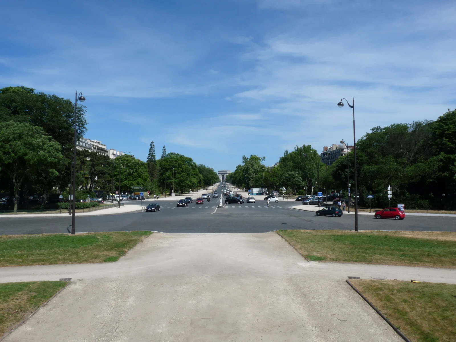 Vue générale de l’avenue Foch bordée d’arbres, avec l’Arc de Triomphe au loin.