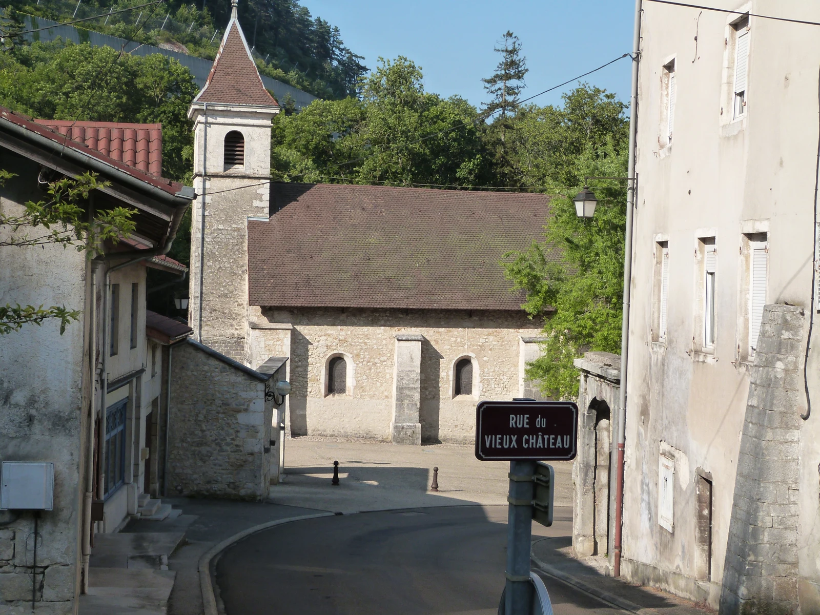Une rue de Montréal-la-Cluse bordée de maisons en pierre descend vers l’église Saint-Maurice.
