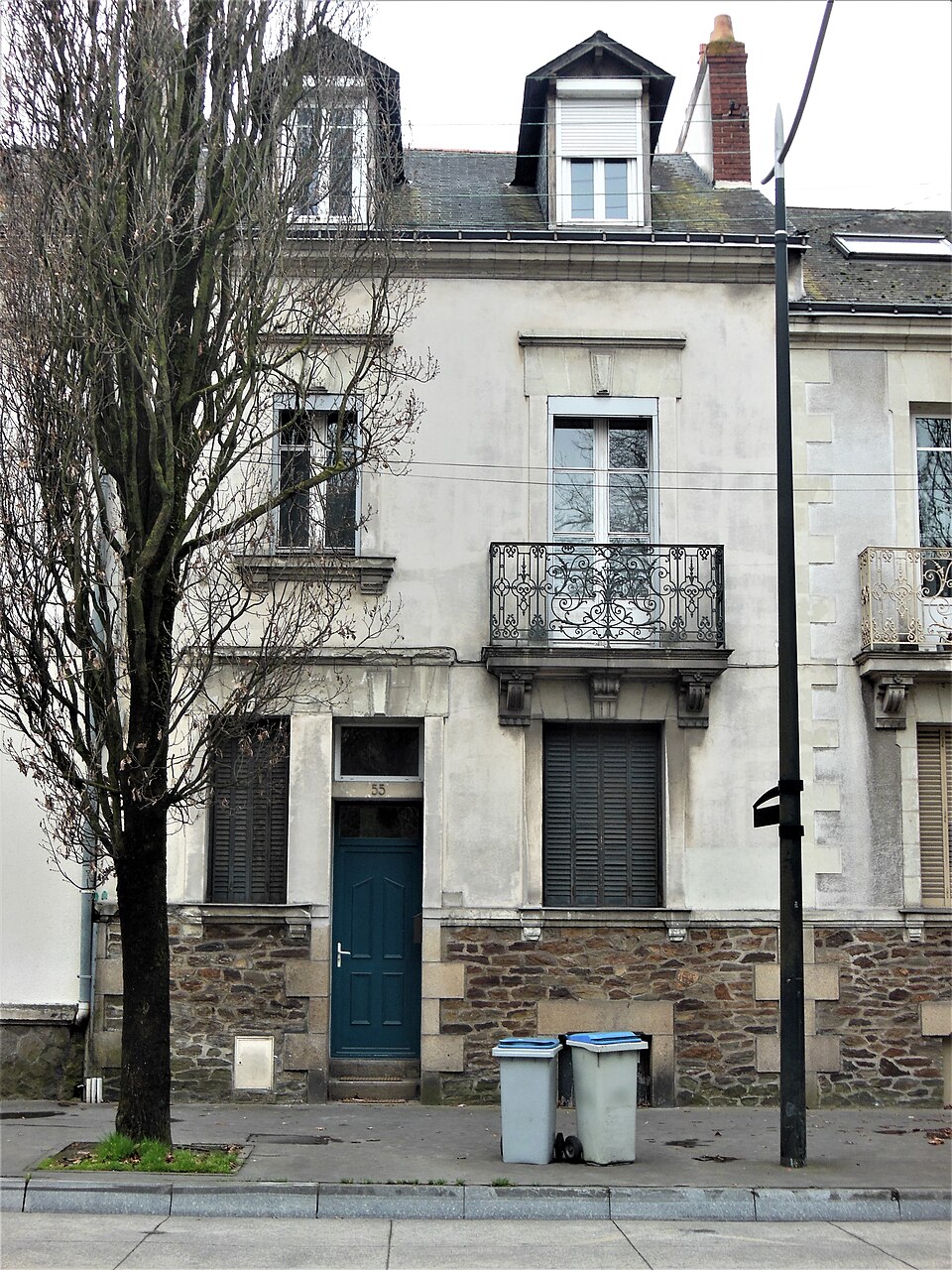 Façade réelle du 55 boulevard Robert-Schuman à Nantes, avec sa porte bleue et son balcon, photographiée en mars 2017.