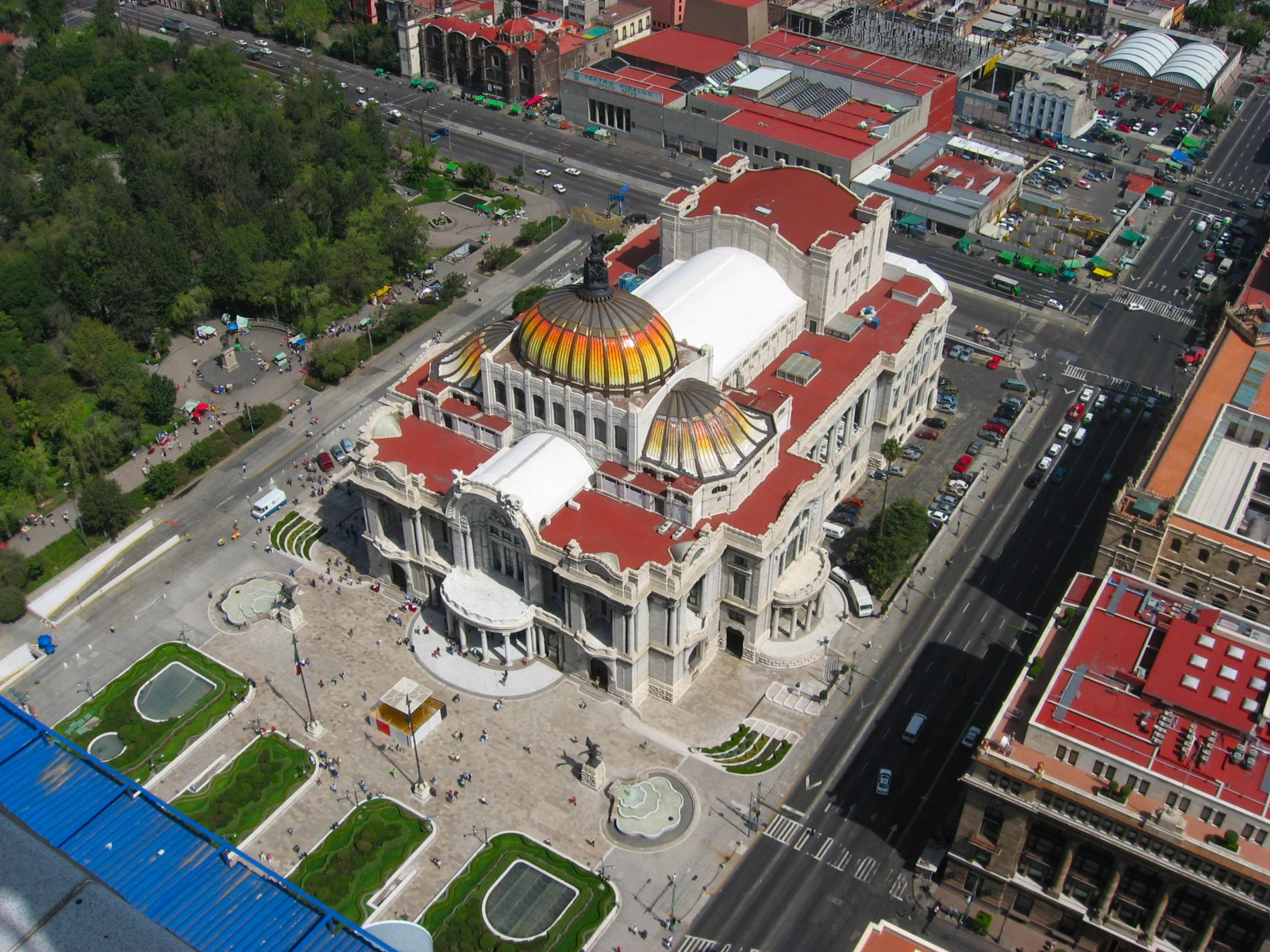 Vue plongeante sur le palais des Beaux-Arts de Mexico, ses coupoles colorées et les rues environnantes.