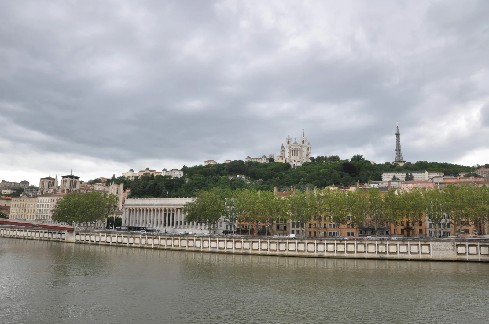 Le palais de justice historique de Lyon au bord de la Saône, avec la colline de Fourvière à l’arrière-plan.