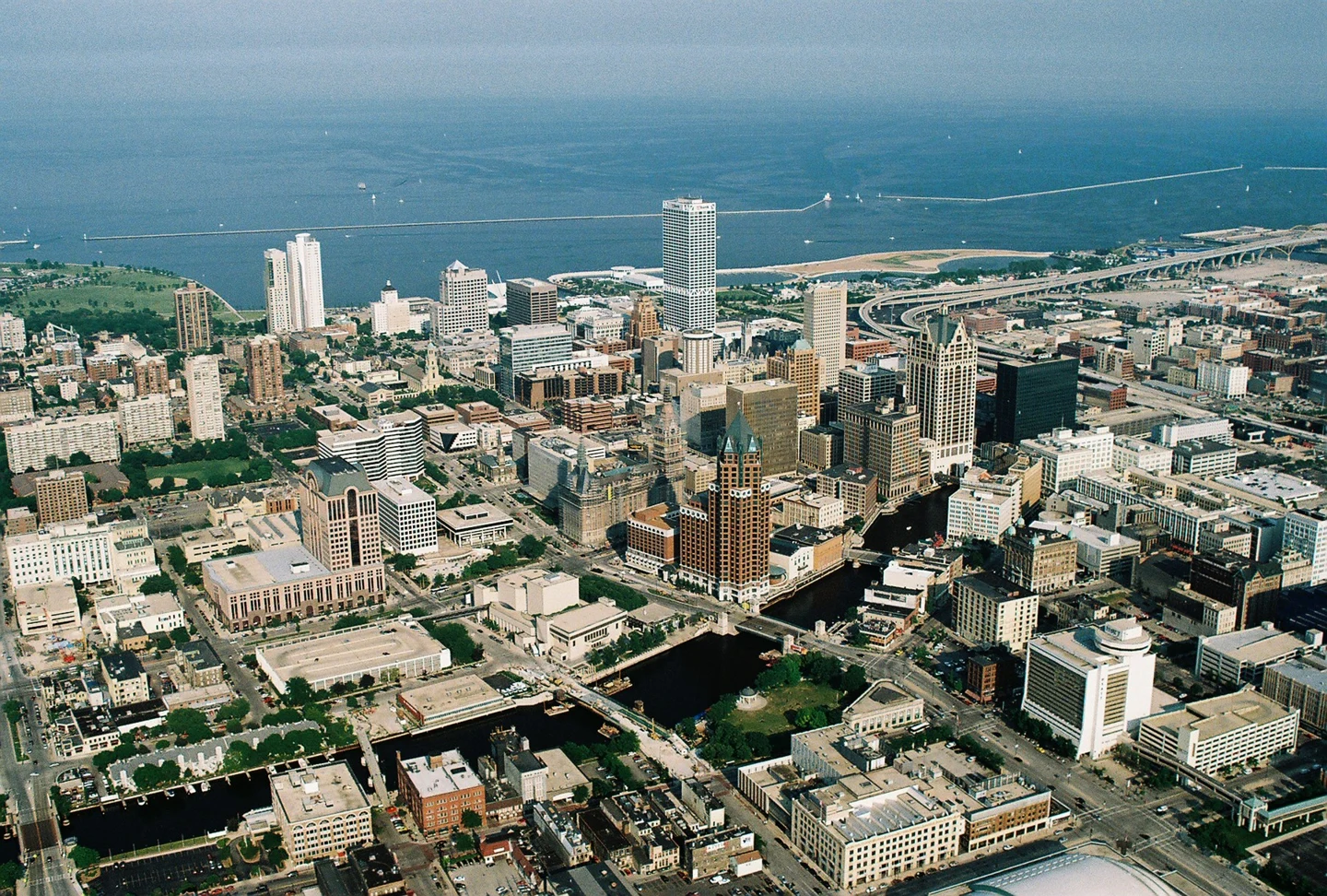 Vue aérienne du centre-ville de Milwaukee, avec la rivière Milwaukee au premier plan et le lac Michigan à l’horizon.