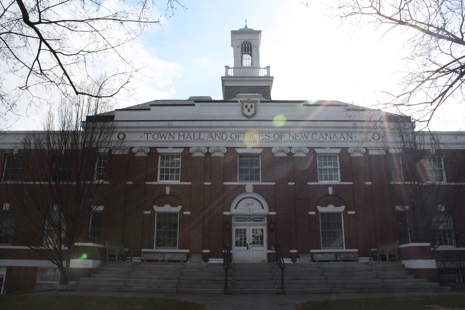 Façade en briques de l’hôtel de ville de New Canaan, avec son entrée centrale, ses marches et son petit campanile.