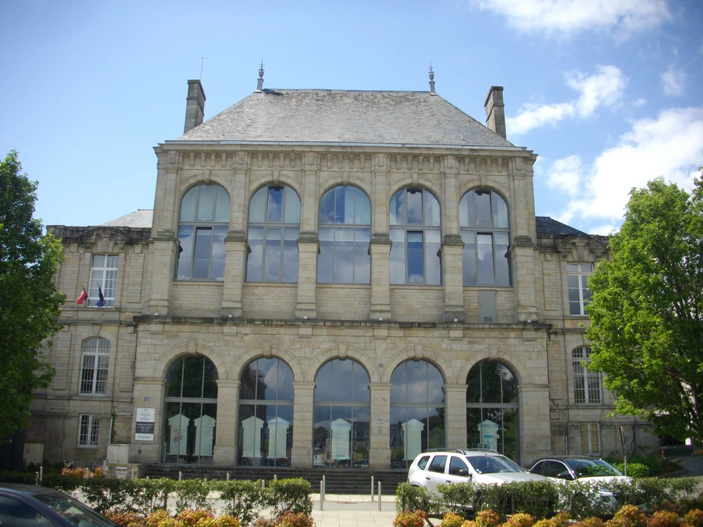 Façade en pierre du palais de justice de Vannes, avec ses grandes fenêtres en arc.