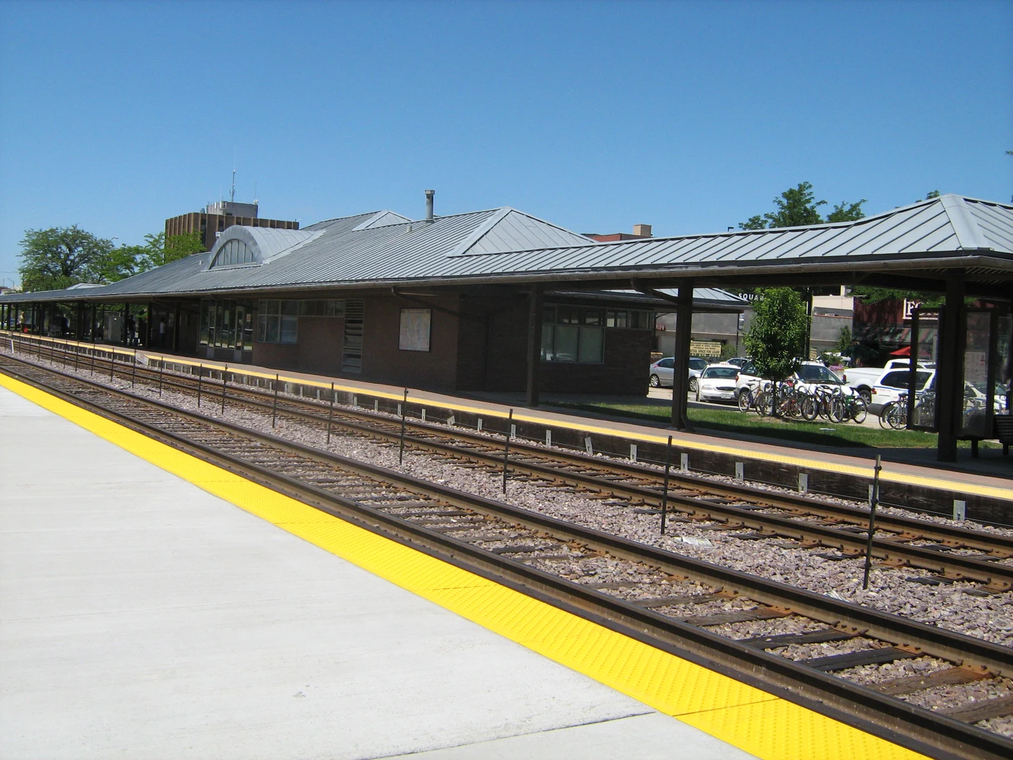 Les voies ferrées et les quais de la gare de Des Plaines, sous un ciel bleu.