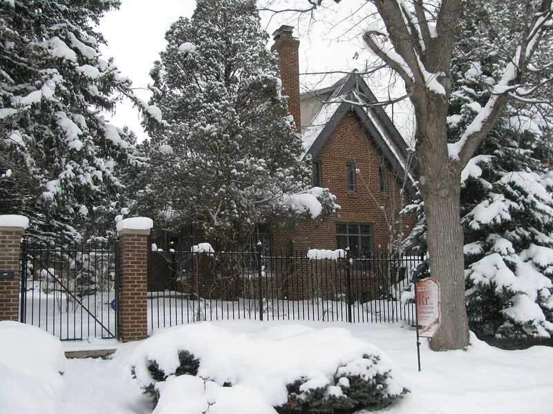 Maison de la famille Ramsey à Boulder, derrière une grille et des arbres enneigés.