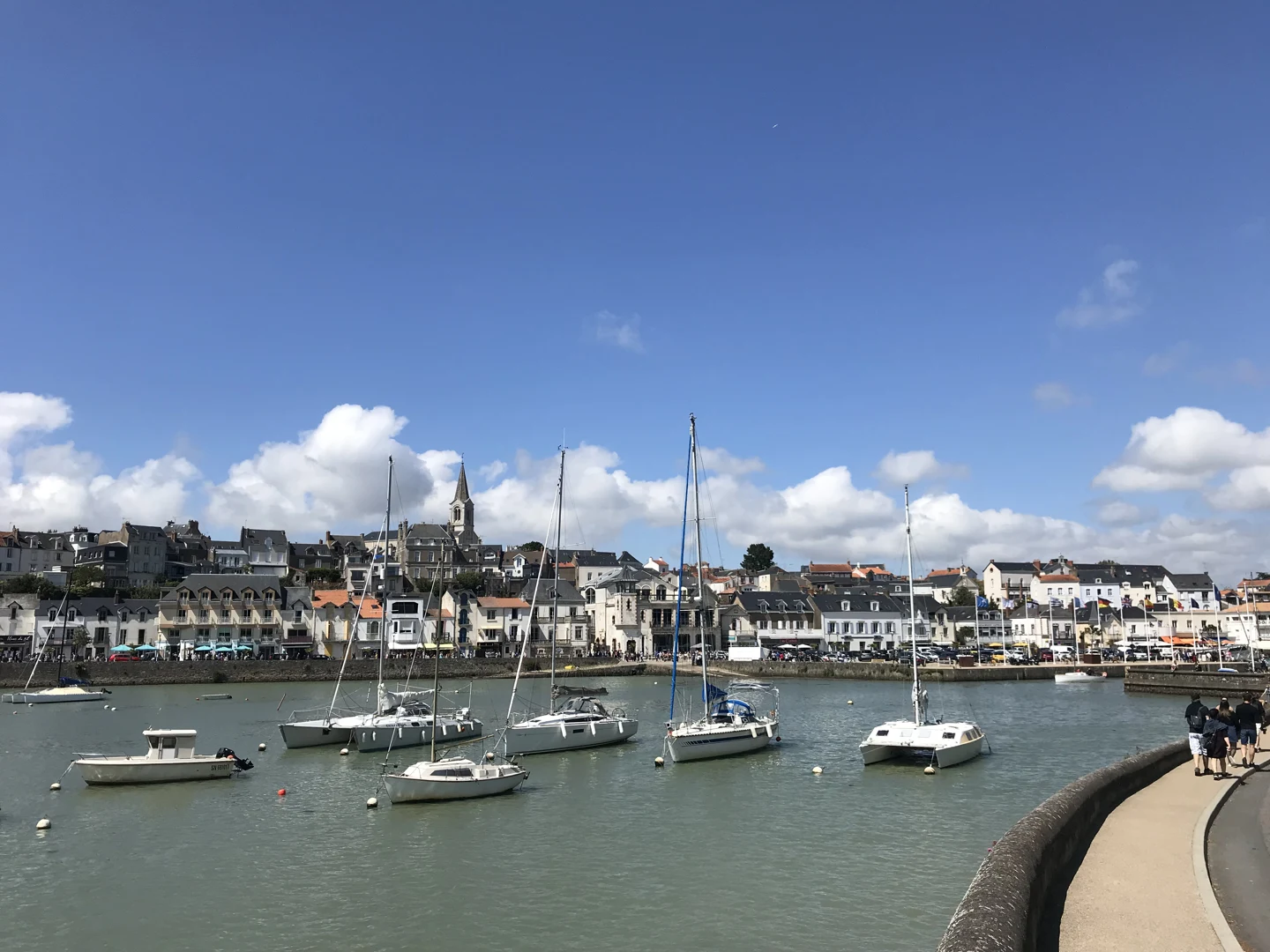 Bateaux au mouillage dans le port de Pornic, devant les façades du centre-ville et le clocher.