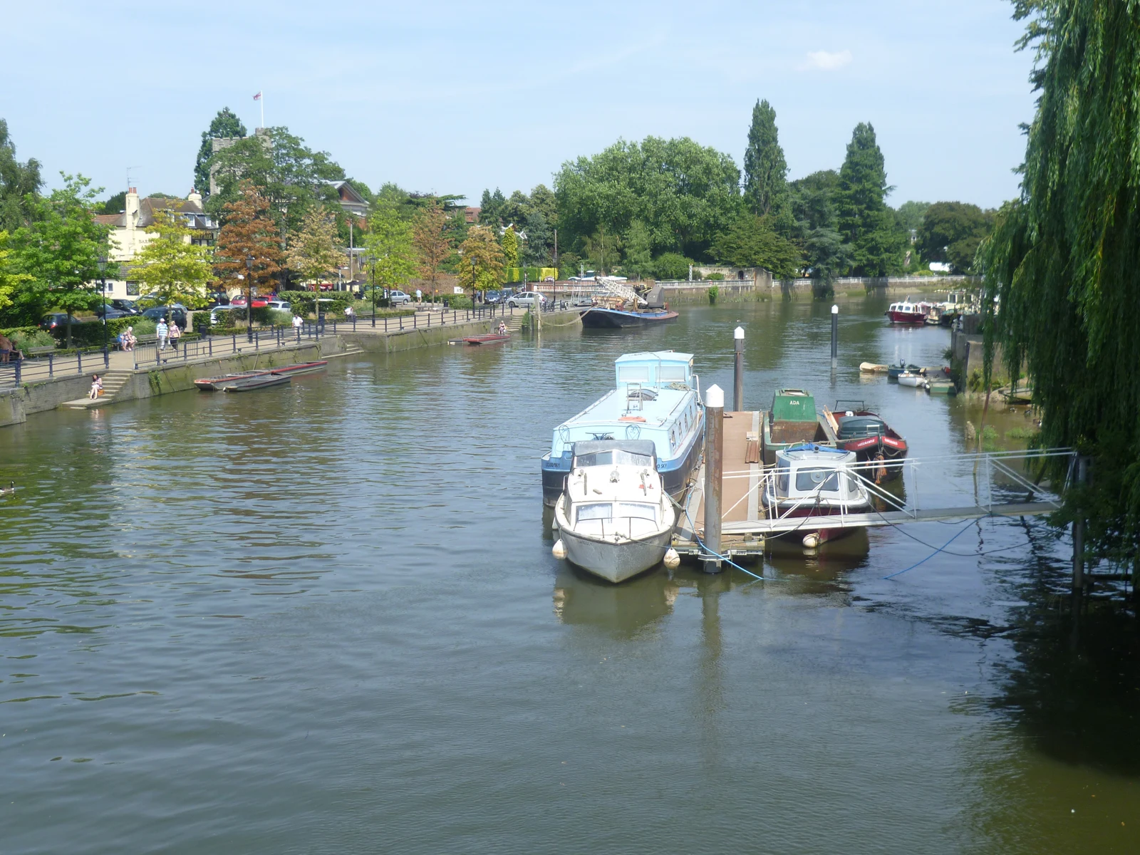 Des bateaux amarrés sur la Tamise, face à la promenade arborée et aux bâtiments de Twickenham.