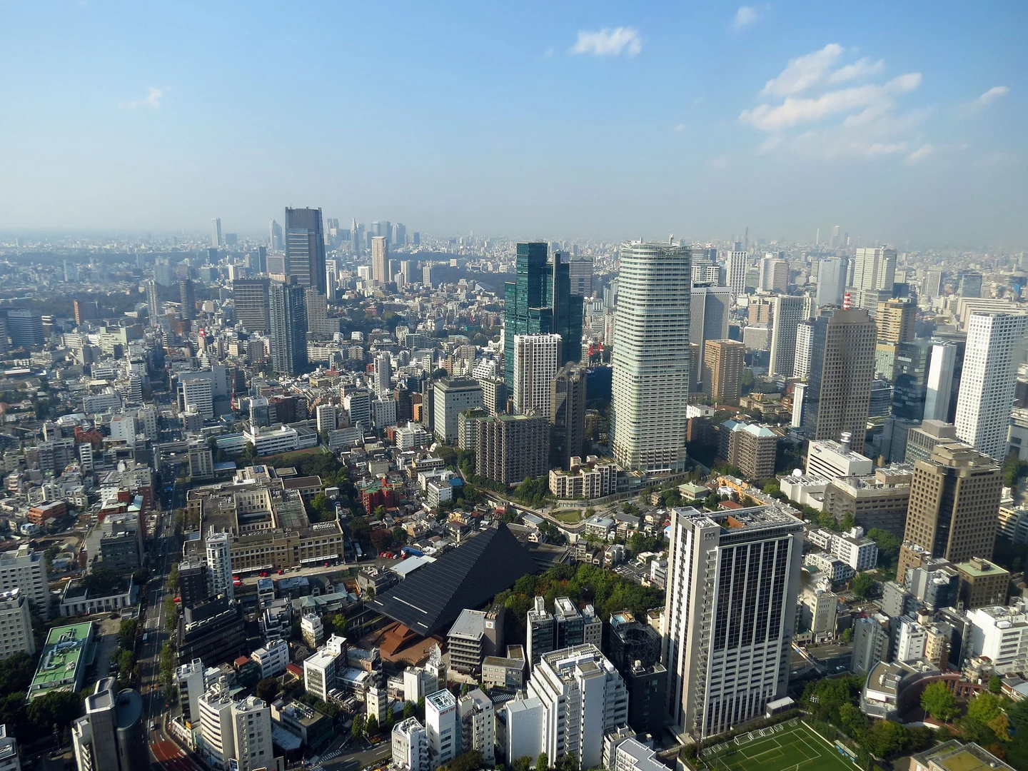 Vue en hauteur des immeubles et des tours du secteur de Roppongi à Tokyo sous un ciel bleu.