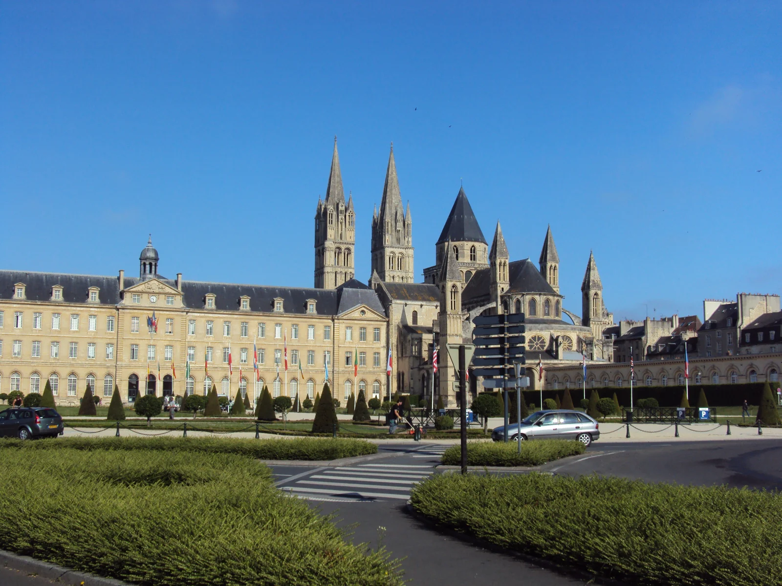 L’hôtel de ville de Caen et les flèches de l’abbaye aux Hommes sous un ciel bleu, vus depuis l’esplanade.