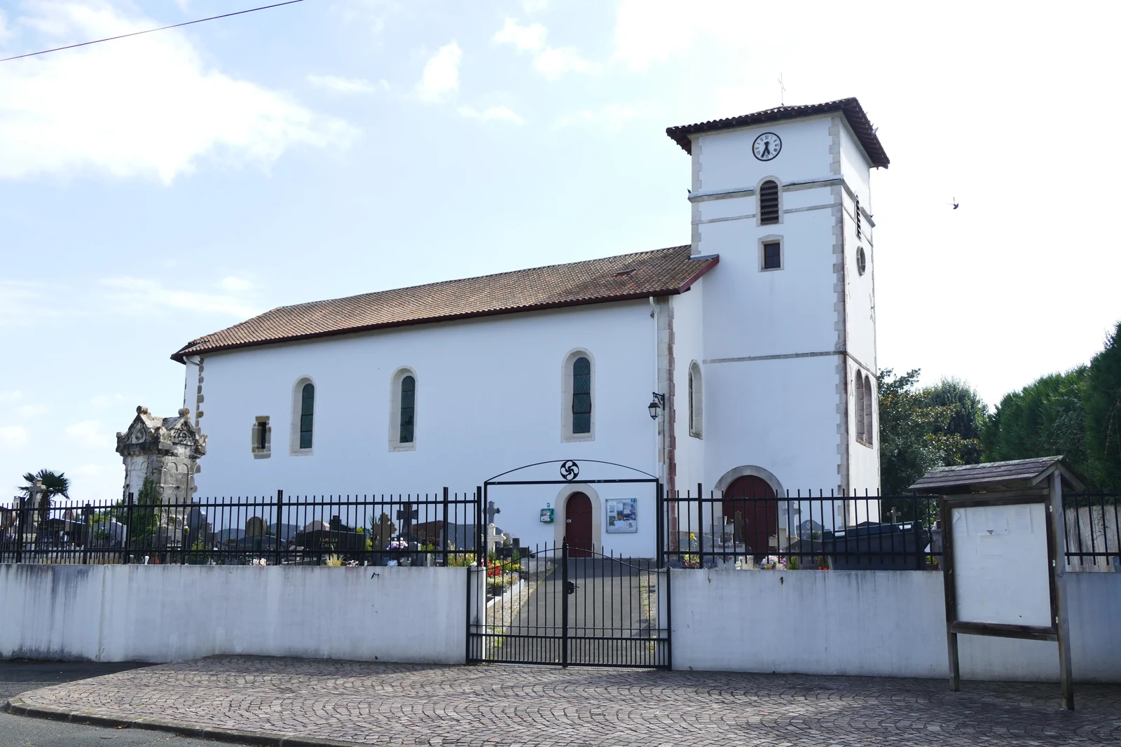 Façade blanche et clocher de l’église de la Présentation d’Arrauntz à Ustaritz, vus depuis la rue.