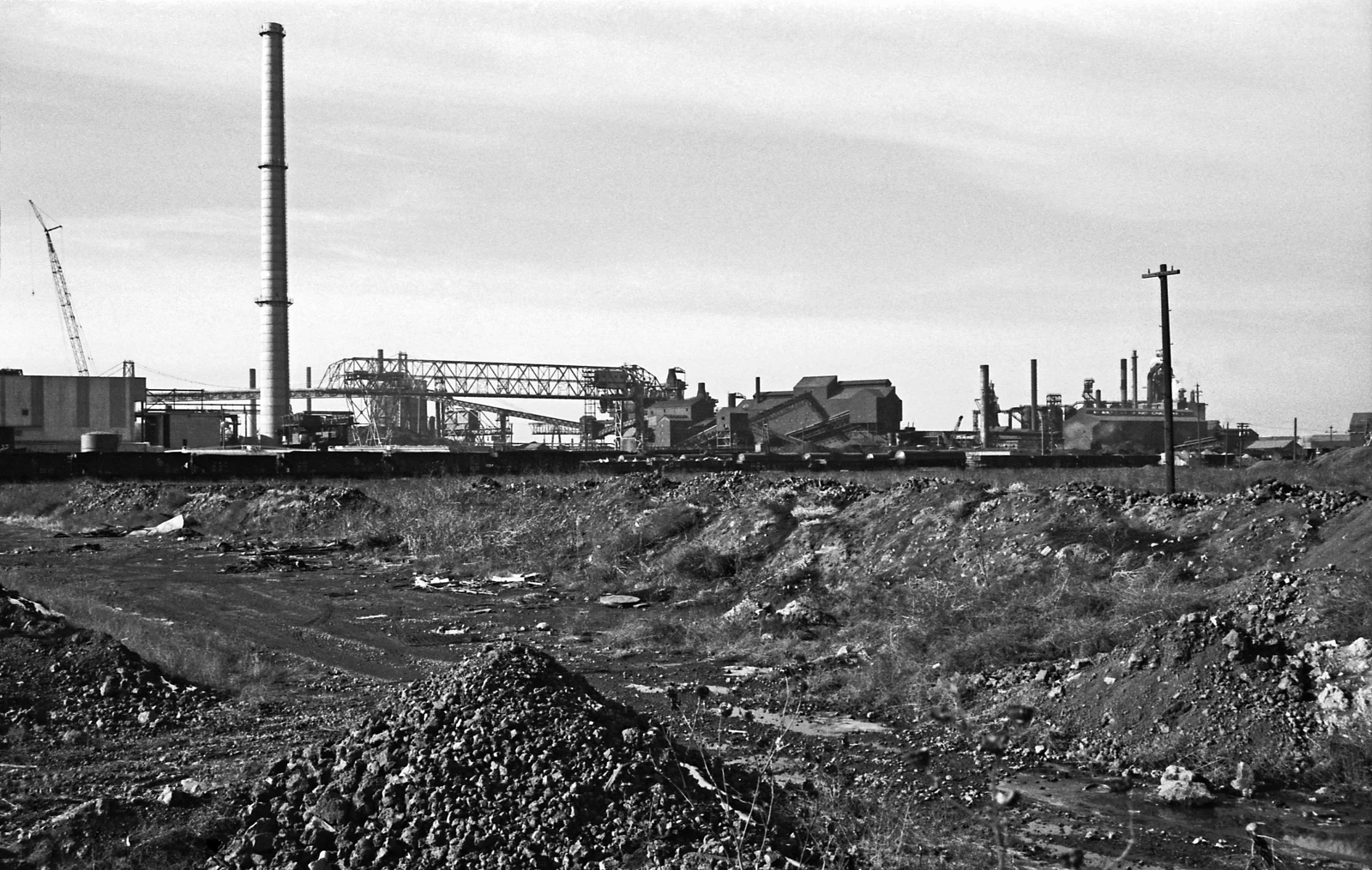 Photographie en noir et blanc de bâtiments industriels, cheminées et installations métalliques à South Chicago.