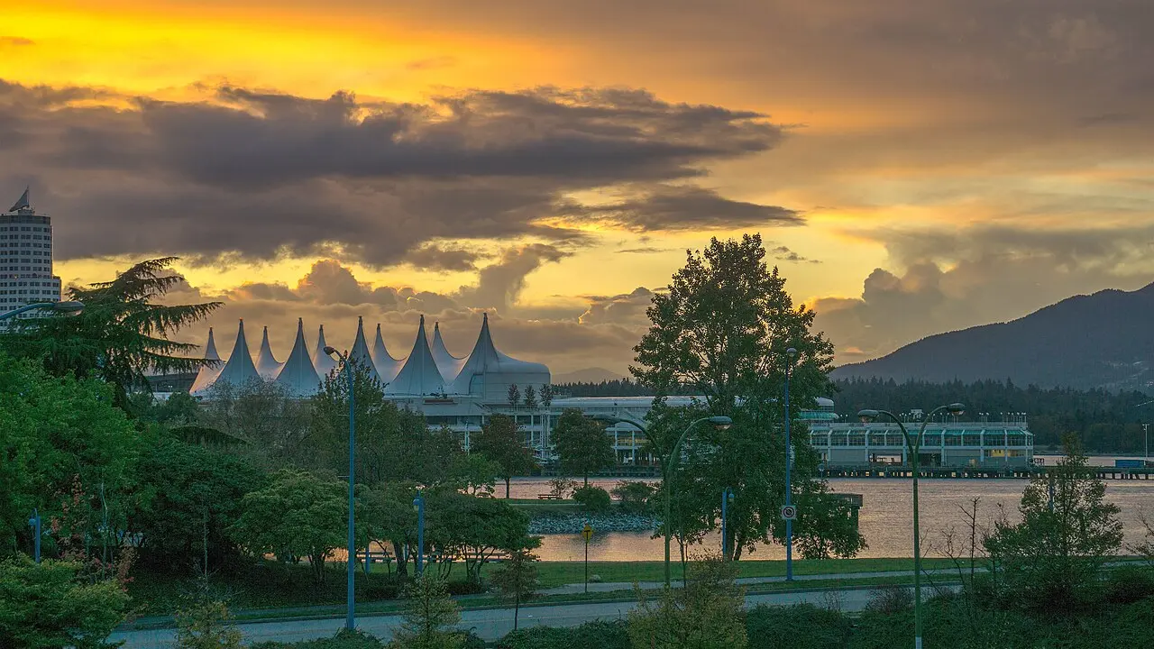 Vue de Vancouver depuis le Downtown Eastside, avec arbres, port, montagnes et ciel du soir.