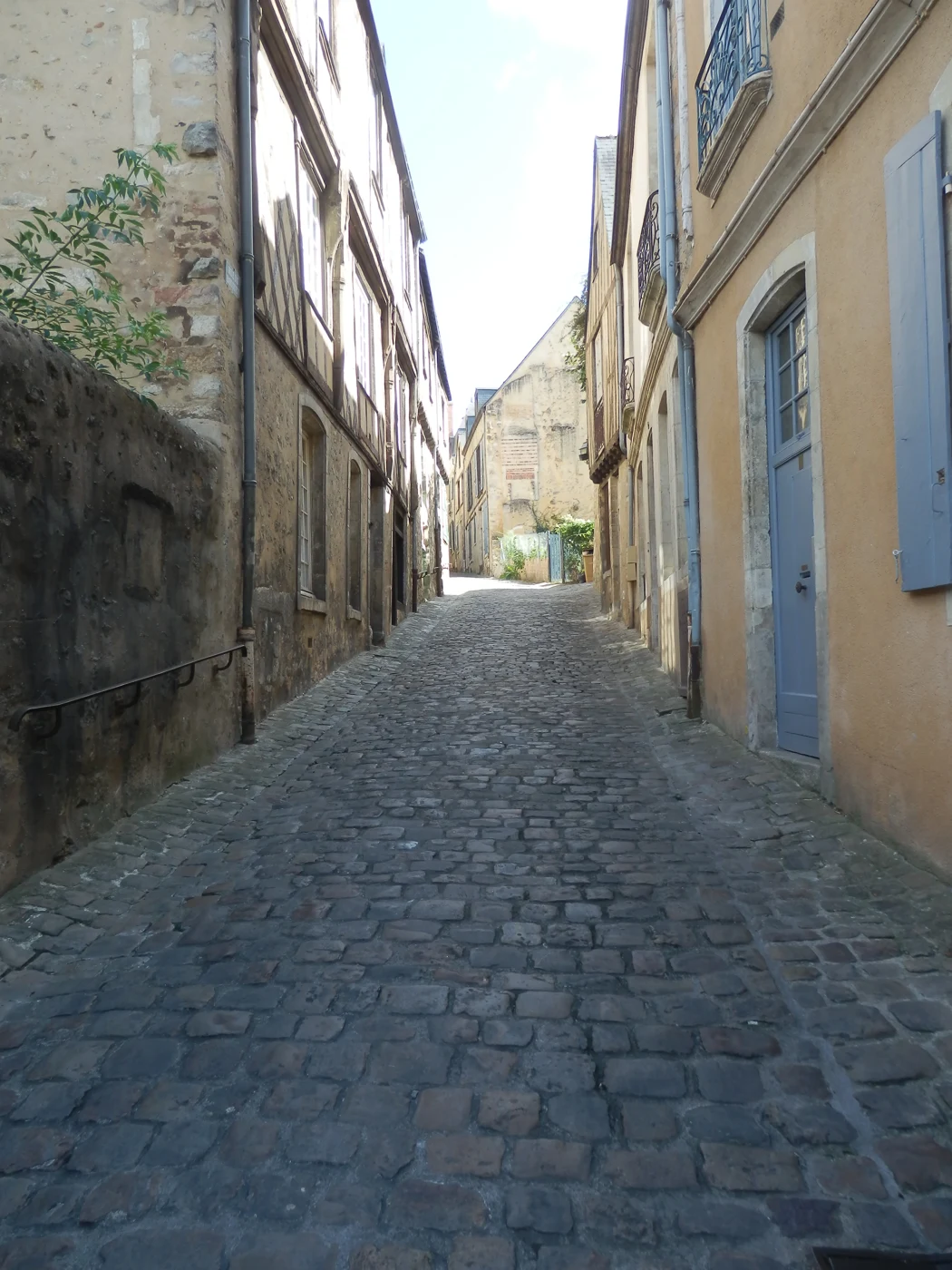Rue pavée bordée de maisons anciennes au Mans.