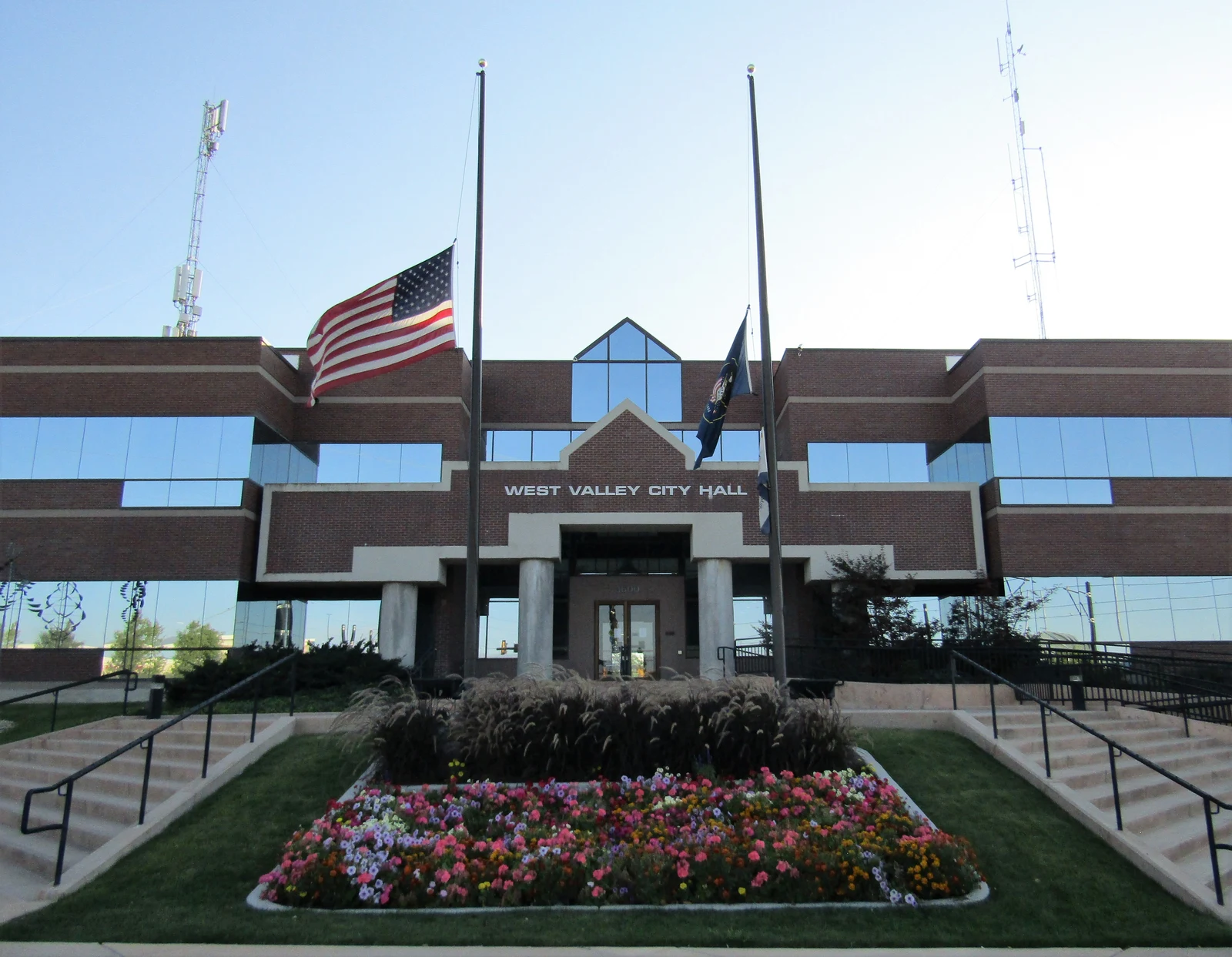 Mairie de West Valley City, dans l’Utah, avec une façade de briques, des fenêtres et un massif de fleurs.
