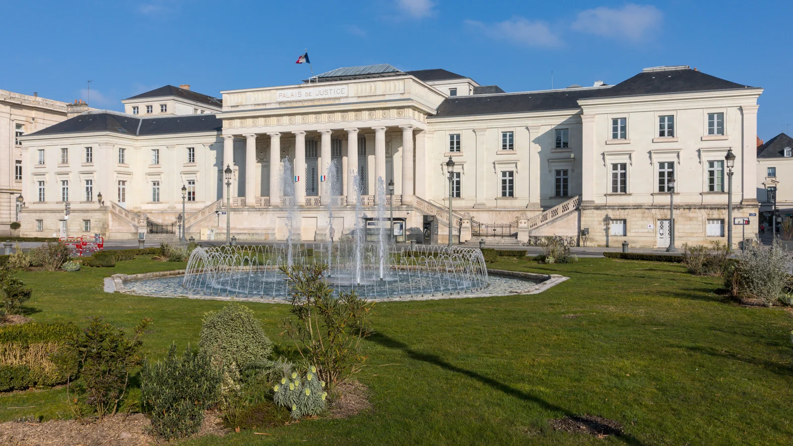 Façade à colonnes du palais de justice de Tours, derrière les fontaines de la place Jean-Jaurès.