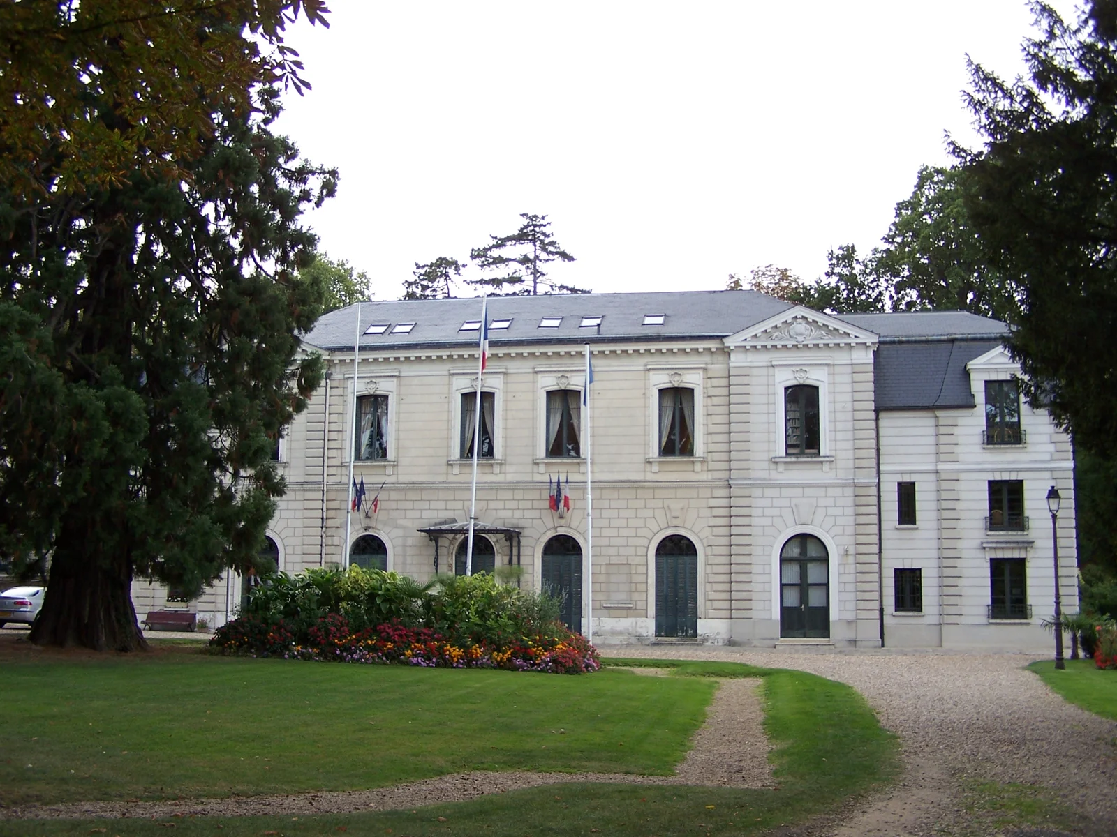 Façade de l’hôtel de ville de Louveciennes et jardin arboré.